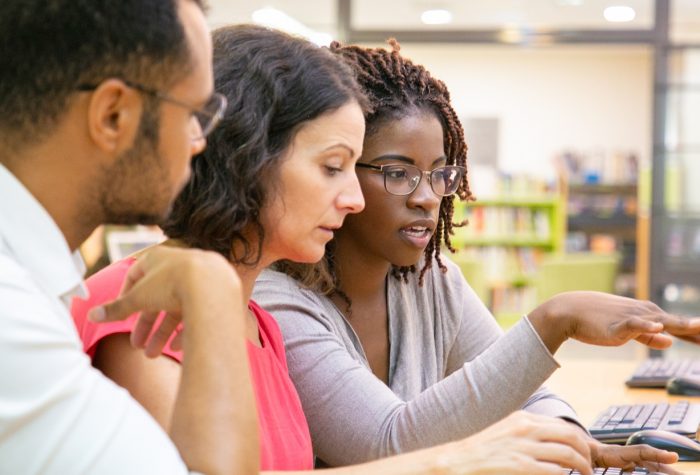Colleagues discussing info on a screen
